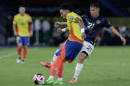 Johan Mojica (i) de Colombia disputa un balón con Alan Franco Palma de Ecuador en el Metropolitano de Barranquilla.