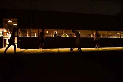 Jóvenes esperan que regrese la energía para jugar fútbol.
