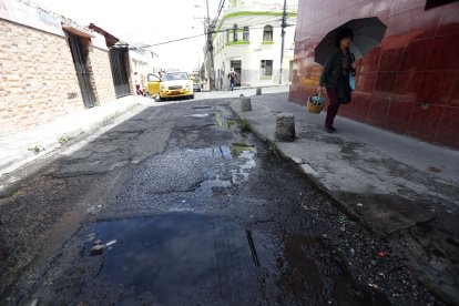 En la calle Villonaco, los vecinos sortean el charco de agua que se forma por la fuga.