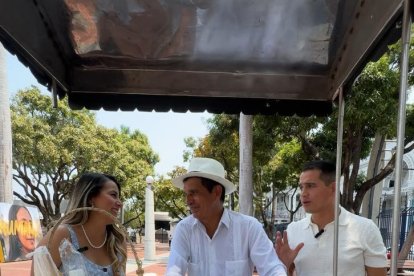 Jorge junto a su papá y hermana, con una de las carretas del negocio.