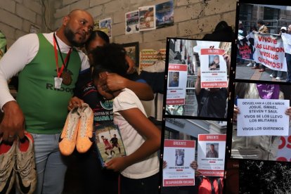 Luis Arroyo y Katty Bustos, abrazados a su hija menor, sostienen entre sus manos los zapatos de Ismael y Josué, sus dos hijos desaparecidos.