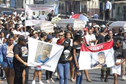 Sepelio de los menores estuvo acompañado de pancartas con mensajes de protesta.