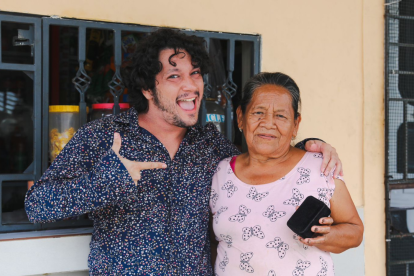 Felipe Crespo entregándole al medalla a la popular Abuelita de la tienda.