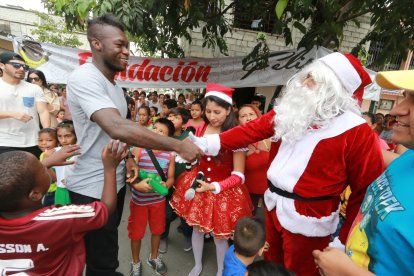 Felipe Caicedo saludando a Papá Noel, en el Guasmo en la entrega de juguetes.