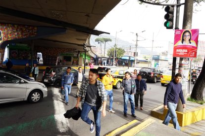 Así deben cruzar los peatones, sorteando los vehículos en la avenida 10 de Agosto.