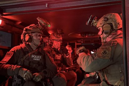 Agentes armados dentro de una camioneta, durante el inicio de una redada contra indocumentados.