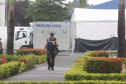 Personal de la Policía Nacional lleva a cabo el traslado de los cuerpos desde el contenedor hasta los vehículos de Medicina Legal.