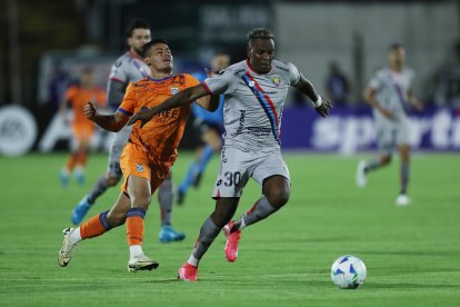 Franklin Carabali (d) de El Nacional en plena disputa del balón con Samuel Garzón de Blooming.