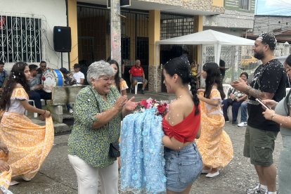 La imagen religiosa es bañada por espuma de carnaval y agua en la fiesta.