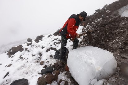 Con un pico, Juan Ushca le da forma al bloque de unas 60 libras que sacó del volcán.