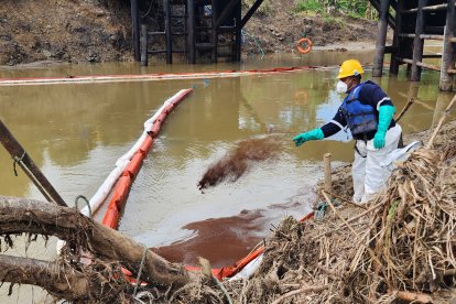 Un contingente arroja polvo absorbente al agua para combatir los residuos del crudo.