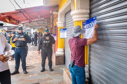 Agentes del Municipio de Guayaquil mientras colocaban los sellos de clausura en establecimientos de La 18.