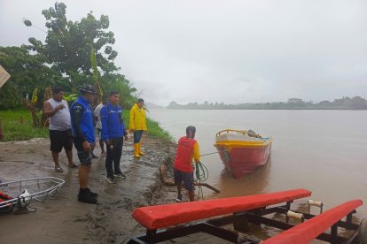 Bomberos y pobladores buscan al menor en el río Esmeraldas.