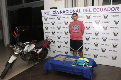 El detenido junto con la droga y la motocicleta incautada en la persecución policial.