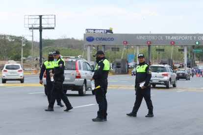 Agentes de la Comisión de Tránsito del Ecuador durante un operativo de control en la carretera.
