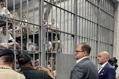 Los ministros Gian Carlo Loffredo (Defensa) y John Reimberg (Interior) observan cómo están los reclusos en la cárcel CECOT del El Salvador.