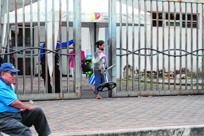Una señora llega al hospital con un ventilador para que su familiar no pase tanto calor.