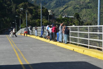 Los turistas observan desde el punto donde la pareja cayó al río.