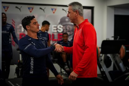 El DT brasileño Tiago Nunes (d) saluda con el ofensivo Alexander Alvarado.