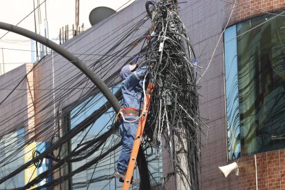 Un trabajador retira los cables inservibles en un tramo de la avenida Rodrigo de Chávez, en el sur de Quito.