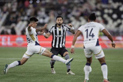 Alex Telles(c) de Botafago disputa el balón con Gabriel Villamíl (i) de LDU Quito .