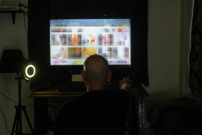 Roberto frente a la computadora, en el espacio donde realiza transmisiones pornográficas en línea.