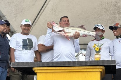 El equipo Caña y Carrete, ganadores del festival, levantan en alto el robalo capturado frente a la costa de Atacames.