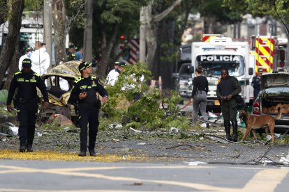 Integrantes de la Policía Nacional inspeccionan la zona tras una explosión ocurrida este jueves en las inmediaciones de la Escuela Militar de Aviación Marco Fidel Suárez, en Cali (Colombia).