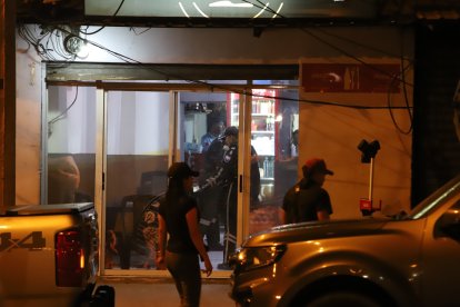 Agentes de Criminalística recolectando los indicios del crimen.