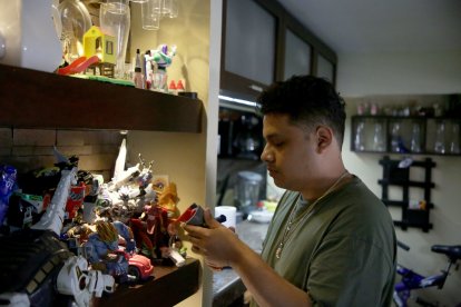 El hermano mayor de Édison Díaz Rodríguez enciende una vela junto a su retrato. Cree en la inocencia de su padre y pide justicia.