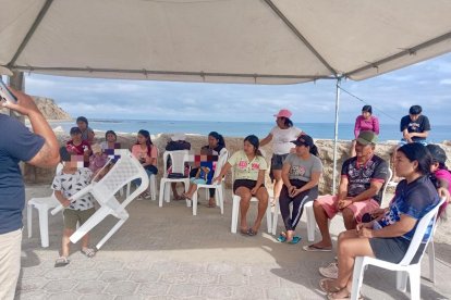 Los familiares aguardan por noticias de los pescadores bajo una carpa en el muelle de San Mateo