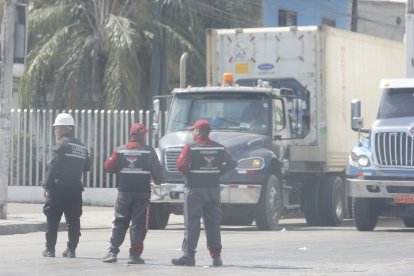Guardias de seguridad de las terminales de la isla Trinitaria custodian las cargas que llegan.