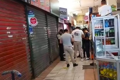 Personal policial revisa los dispositivos con las grabaciones en donde se observa el crimen del vendedor de teléfonos celulares