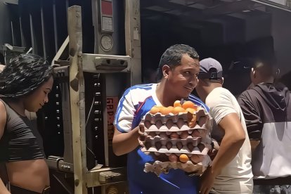 Un ciudadano lleva varias cubetas de huevos que sacó del camión que se volcó en la carretera E15, en la parroquia San Mateo.