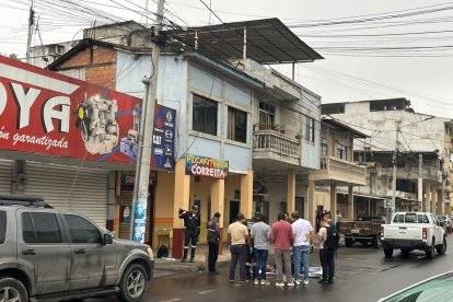 Agentes policiales levantaron el cuerpo del guía carcelario que fue cubierto con una sábana blanca.
