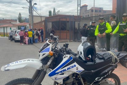 Policías custodian la Unidad de Flagrancia de Cuenca mientras familiares de los detenidos aguardan por infurmación.