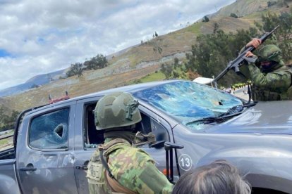 Un militar retira los restos del parabrisas tras el ataque a la caravana presidencial en Cañar.