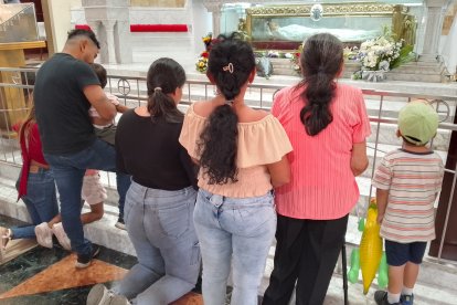 Fieles arrodillados contemplan y oran a Santa Narcisa de Jesús en su santuario.