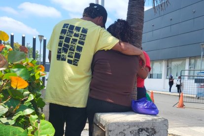 La madre del adolescente asesinado recibe el consuelo de su hija y su yerno. Llegó a la morgue para retirar el cuerpo de su hijo.
