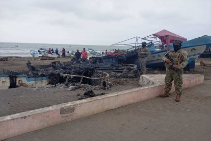 Los restos de las siete embarcaciones quemadas, vigiladas por personal de las Fuerzas Armadas.