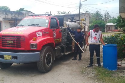 Un tanquero del Cuerpo de Bomberos de Quinindé abastece de agua a una casa del recinto Santa Elvira, el más cercado a la zona del derrame.