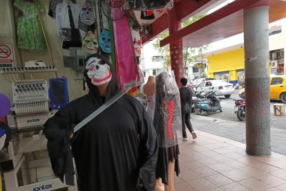 Un vendedor con una máscara de monstruo tuerto atrae al público.