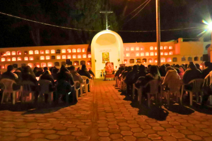 Las familias viven la tradición de sus ancestros de encender velas para los difuntos.