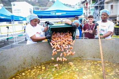 Un grupo de mujeres agrega chorizo ahumado al Tapao Arrecho más grande dle mundo preparado este sábado en Esmeraldas.