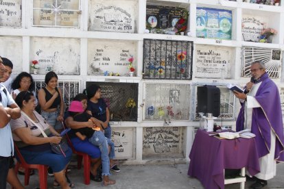 Familias católicas optaron por realizar pequeñas ceremonias religiosas al pie de las tumbas de sus seres queridos.