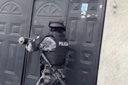 Un uniformado ingresa por la fuerza a un inmueble durante los operativos para capturar a los policías señalados en corrupción.