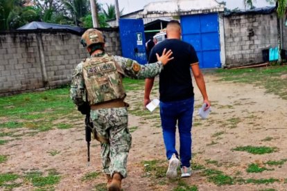 Un militar traslada al presidente de mesa detenido en Galera, tras hallársele cuatro papeletas en blanco durante la jornada electoral en Muisne.