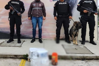Agentes policiales junto al paquete contaminado con cocaína.