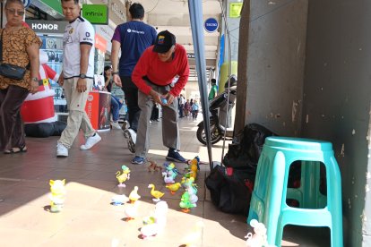 Transeúntes y trabajadores de la zona observan el espectáculo de los animalitos de juguete que pondrá en promoción Ramón Recalde.