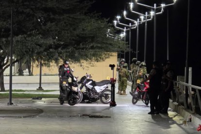 Fuerzas policiales y de Infantería de Marina patrullan el malecón de Puerto Bolívar tras un ataque armado desde el mar, que dejó un fallecido y un herido.